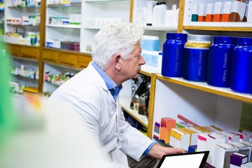 Wall Mural - Pharmacist holding digital tablet while checking medicine