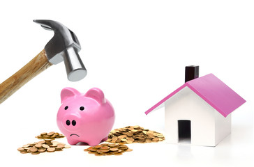 Wall Mural - Hammer is about to hit a pink piggy bank in order to buy a house / Thinking of buying a new house - saving money for future concept