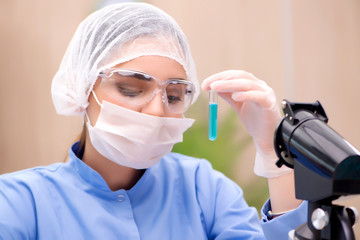 Lab chemist working with microscope and tubes