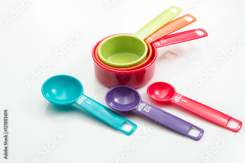 Fotografia, Obraz Plastic measuring cups and spoons on a white background.