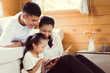 © torwaiphoto - Asian family tablet uses a pen to write. are playing at home.