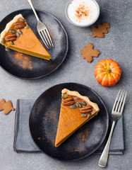 Wall Mural - Pumpkin pie, tart made for Thanksgiving day with whipped cream on a black plate. Top view