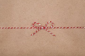 Christmas string or twine tied in a bow on kraft paper background