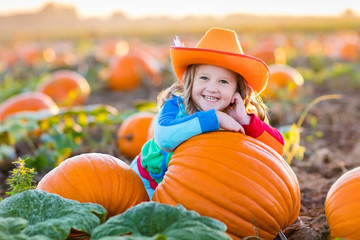 child playing on pumpkin patch