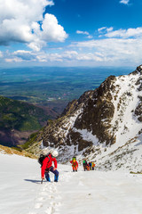 Wall Mural - Group of climbers rises thru snow towards the summit. View from above. Weather is good. Mountaineering in High Tatras, Slovakia