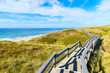 © pkazmierczak - Wooden walkway along a coast of North Sea and view of beautiful beach near Wenningstedt village, Sylt island, Germany
