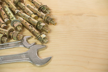 wrench Bolts and screws used in construction on the wood backgro