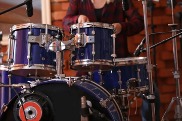 Woman playing drums in a recording studio