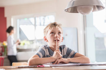 focus on a young boy doing his school homework, at home