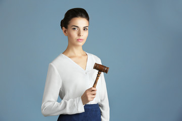 Wall Mural - Woman with judge gavel on gray background