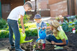 © Oksana Kuzmina - Little boys watering plant with his mother in garden