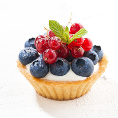 Sticker - mini tart with cream and berries on white background, closeup