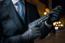 Hitman Or Assassin Holds Pistol With Silencer In Hands.