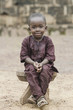 Sitting boy outdoors - African proud child