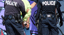 Two Police Officers Arrest And Handcuff Homeless Woman In Venice Beach, Los Angeles, California.
