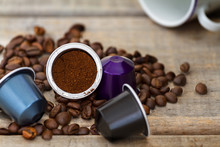 Italian Espresso Coffee Capsules Or Coffee Pods On Wood Background With Some Roasted Coffee Beans