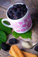 Wall Mural - Cup of fresh natural blackberries with biscuits