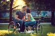 © Fxquadro - Handicapped young couple on two wheelchairs kissing .