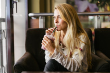 Blonde woman drinking a strawberry milkshake