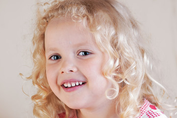 little curly blond caucasian girl looking dreamily into the distance