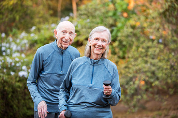 Wall Mural - Fit older couple standing in garden