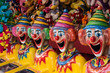Row of clown heads in carnival side show alley with prizes
