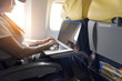 © mangpink_s - asian tourist  woman using  laptop at airplane with sunlight