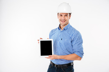 Happy man architect in building helmet holding blank screen tablet