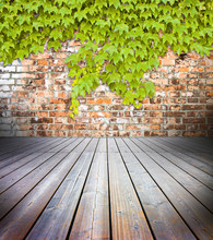 Hardwood Floors With Brick Wall On Background Covered With Green