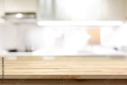 Wood countertop (or kitchen island) on blur kitchen interior background ...