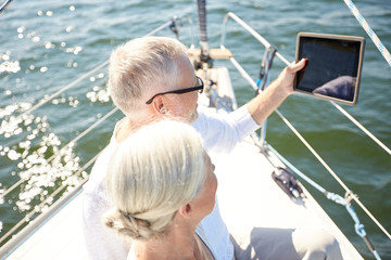 Sticker - senior couple with tablet pc on sail boat or yacht