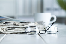 Stack Of Newspapers And Eyeglasses