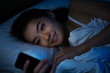 © torwaiphoto - Asian women are using the smart phone on the bed before she slee
