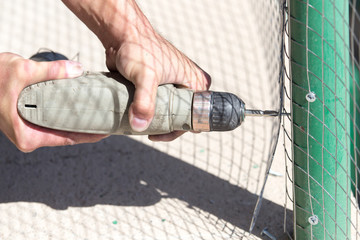 Wall Mural - Worker twists the screw into the metal