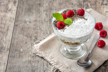 Wall Mural - Chia yogurt with raspberries in a glass cup on wooden table

