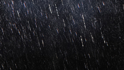 falling raindrops footage animation in slow motion on dark black background with fog, lightened from