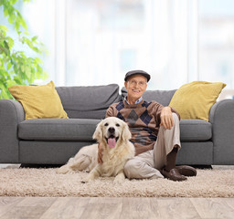 Poster - Elderly man sitting on the floor with his dog