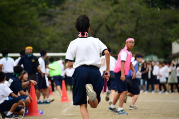 Wall Mural - Students running in a field. Sports day in Japan.