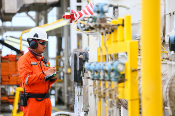 operator recording operation of oil and gas process at oil and rig plant, offshore oil and gas industry, offshore oil and rig in the sea, operator monitor production process, routine daily record.