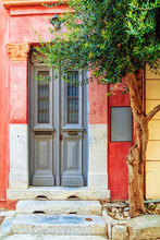 Wooden Grey Front Door On A Red Old House With Decoration Columns. Vertical Shot