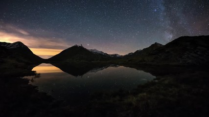 Wall Mural - the apparent rotation of the milky way and the starry sky beyond snowcapped mountain ridge, reflecte