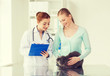 © Syda Productions - happy woman with cat and doctor at vet clinic