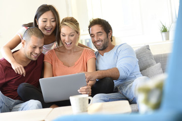 Wall Mural - Group of friends sitting in couch websurfing on internet