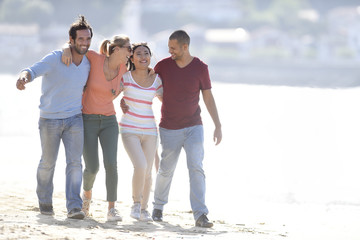 Wall Mural - Group of friends walking on the beach