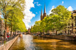 Scenic European Amsterdam Canal with church spires on sunny summer day