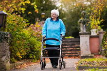 Senior Lady With A Walker In Autumn Park