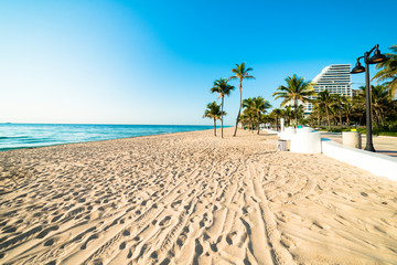 White sand deserted Fort Lauderdale South Florida beach stretching out under beautiful blue cloudless sky