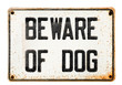 Rusted metal tin Beware Of Dog sign placcard isolated on white background