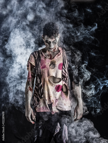 Plakat Męska zombie pozycja na czarnym tle, patrzeje kamerę. Motyw Halloween