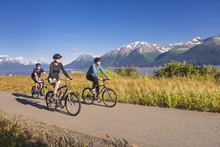 Two Women And A Man Biking On The Bird Point To Girdwood Bike Trail, Turnagain Arm;Anchorage, Alaska, United States Of America